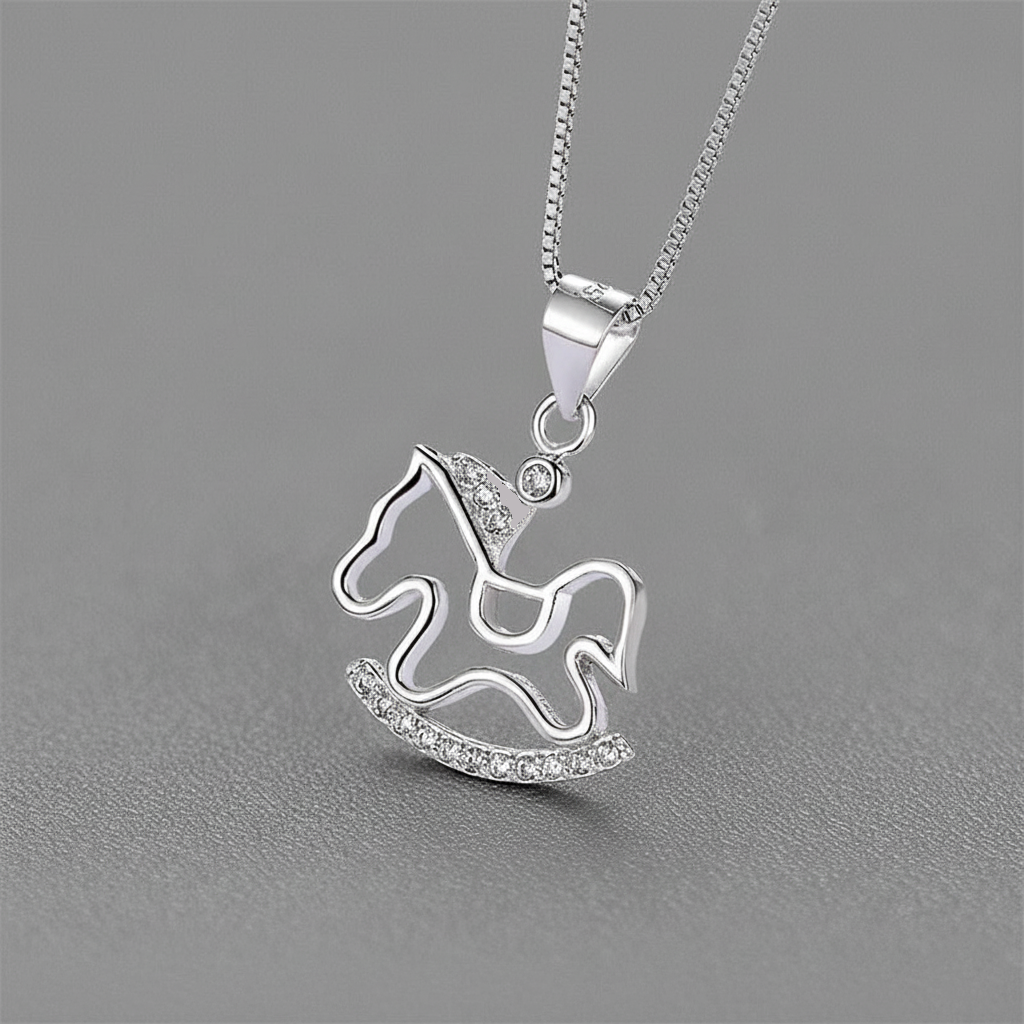 Silver rocking horse pendant necklace on a gray background