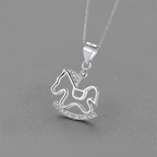 Silver rocking horse pendant necklace on a gray background