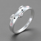 Silver ring with pink accents on a gray background