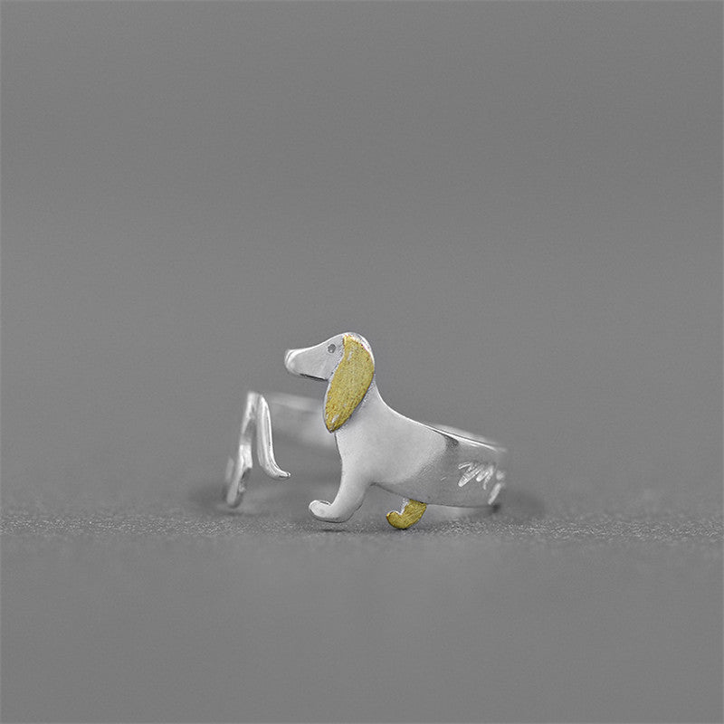 A silver adjustable ring featuring a cute dachshund dog design with a gold plating detail.