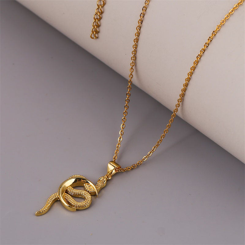 A gold-colored snake-shaped pendant necklace with a long chain.